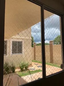 Rede de proteção para janela ampla com vista para quintal ajardinado no bairro Coronel Antonino em Campo Grande MS - UauTelas Bairro Coronel Antonino MS
