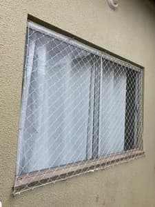 Vista lateral de rede de proteção instalada em janela com peitoril de granito - UauTelas Terenos MS