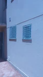 Redes de proteção brancas instaladas em janelas pequenas de ventilação em parede externa no bairro Planalto em Campo Grande MS - UauTelas Bairro Planalto MS