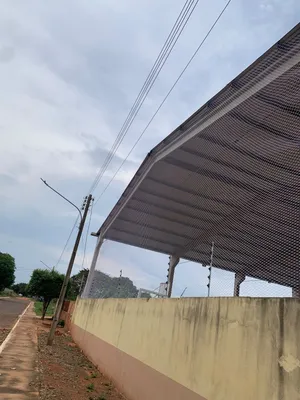 Vista externa da fachada da quadra coberta protegida com rede branca malha 5x5 cm em Dois Irmãos do Buriti MS - UauTelas