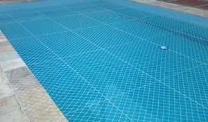 Rede de proteção branca para piscina com malha tensionada sobre água cristalina no bairro Autonomista em Campo Grande MS