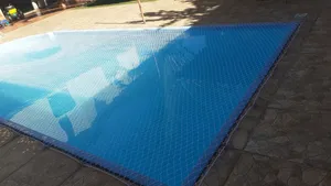 Rede de proteção branca para piscina instalada sobre deck de cerâmica rústica no bairro Tarumã em Campo Grande MS