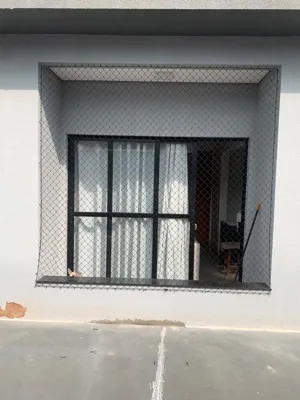 Detalhe do acabamento e ancoragem da rede de proteção preta em sacada no Bairro Monte Castelo - UauTelas